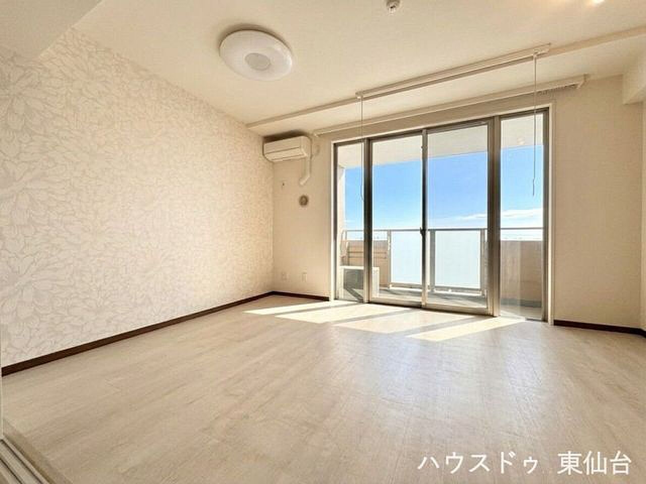 空が入る掃き出し窓と、床に伸びる光の帯